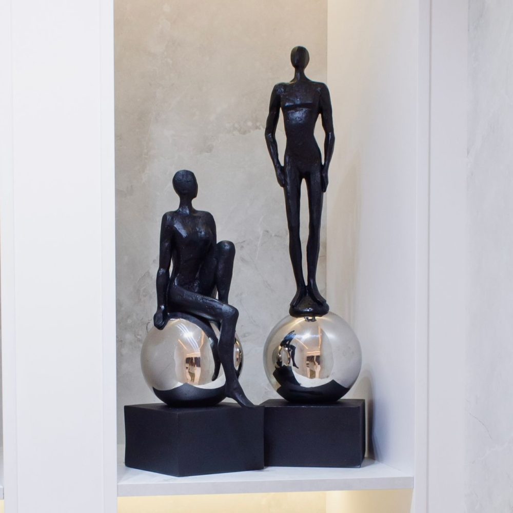 Escultura de Hombre Parado Sobre una Esfera de Acero Color Negro