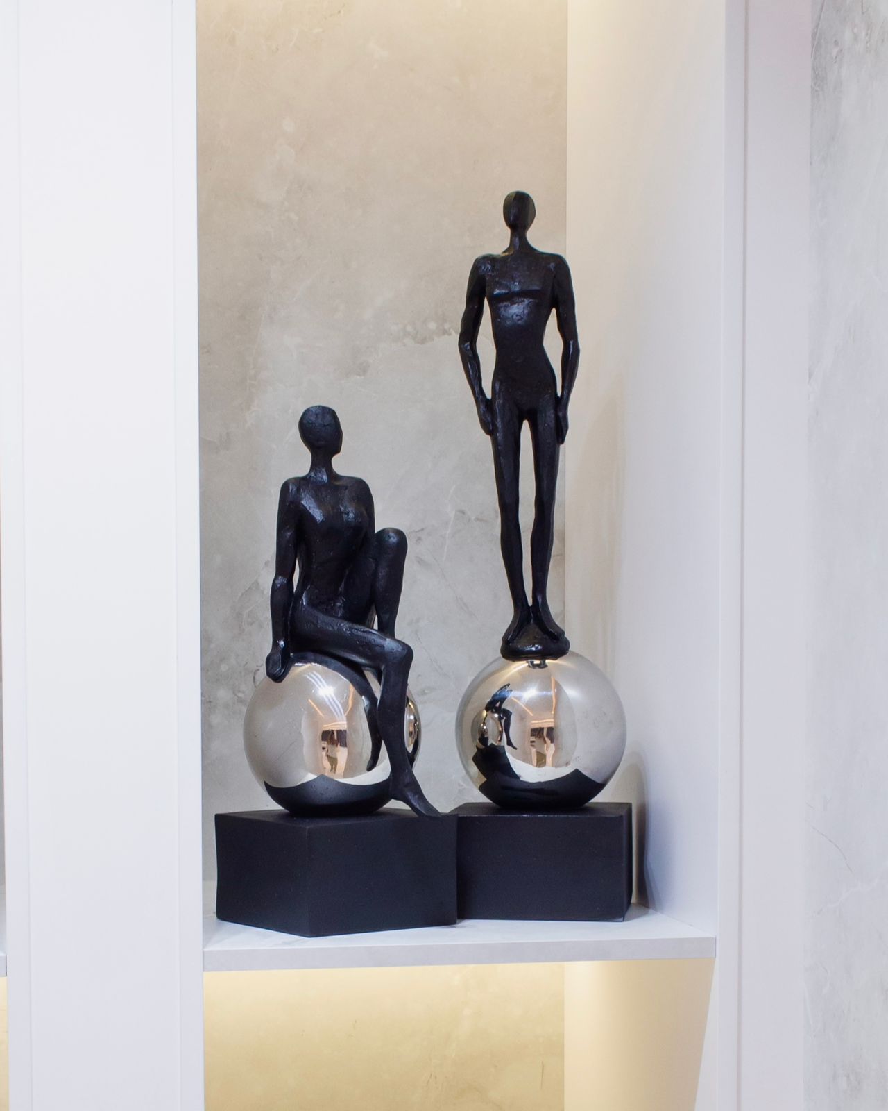 Escultura de Mujer Sentada Sobre una Esfera de Acero Color Negro